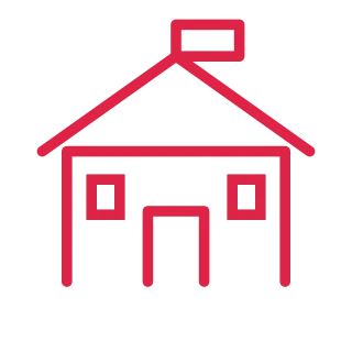 A symmetrical school building has a pitched roof, two windows and a small flag.