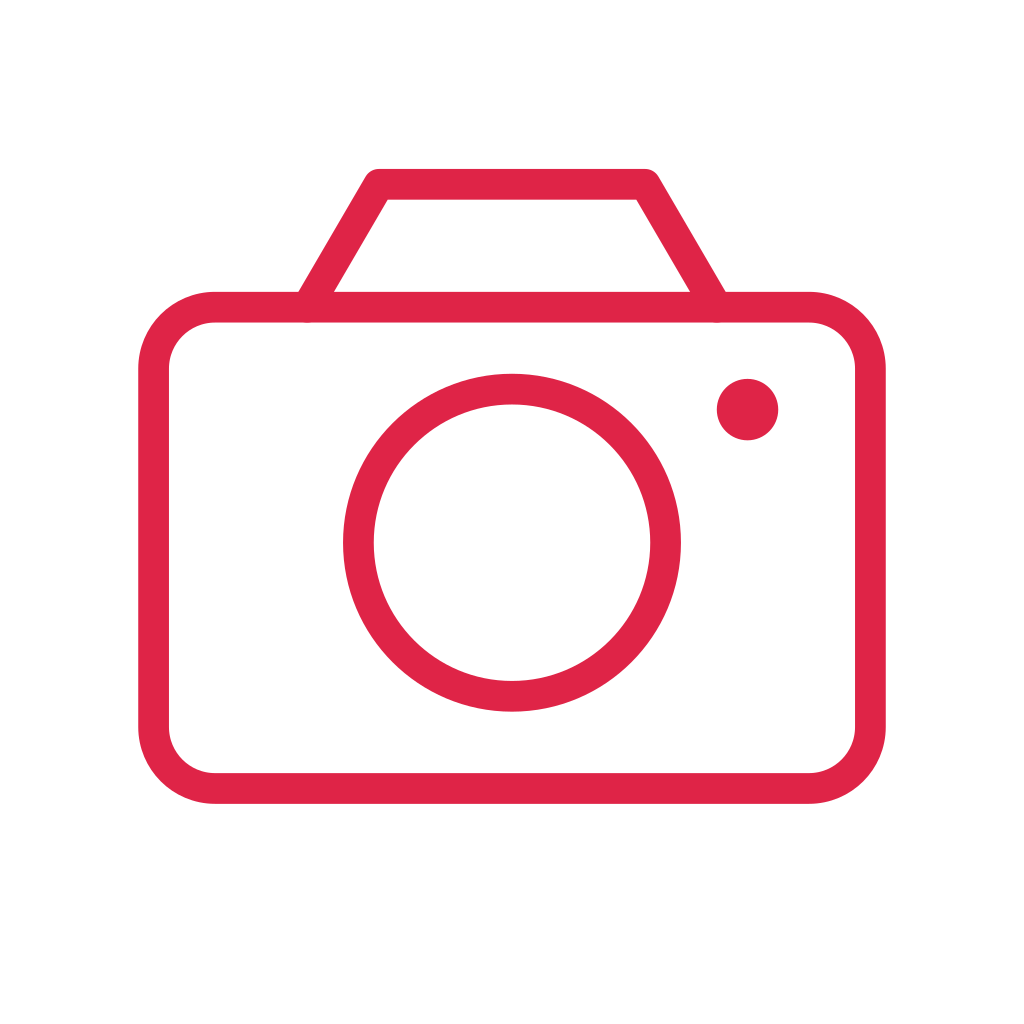 A camera body has a stepped top, circular lens and a small indicator light.