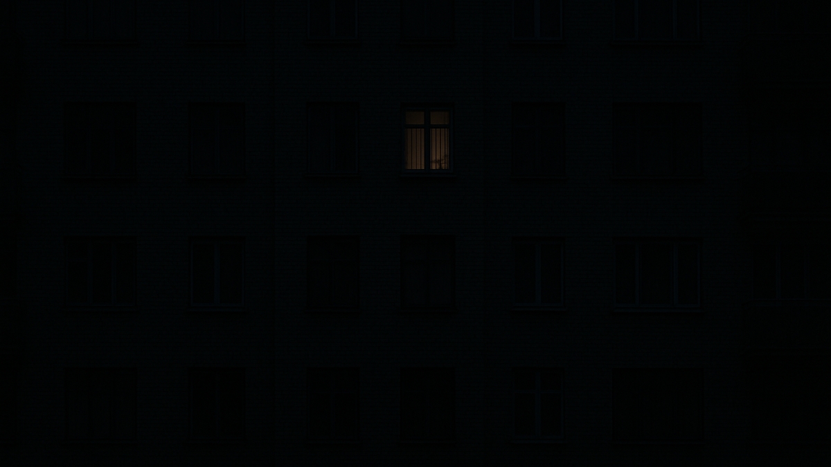 Sötét lakóház egy kivilágított ablakkal, amely meleg belső világítást mutat.